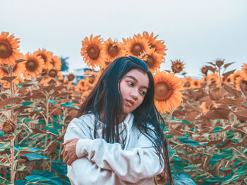 Portrait of young woman standing against sky