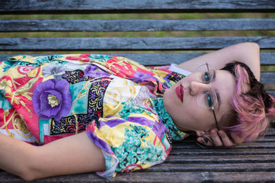 Portrait of young woman lying on bench