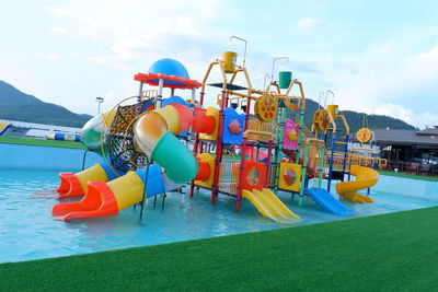 View of amusement park by swimming pool against sky