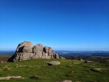 Hay tor rock formation against blue sky