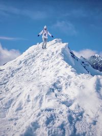 Low angle view of person walking down snowcapped mountain