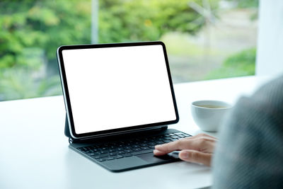 Midsection of woman using laptop on table