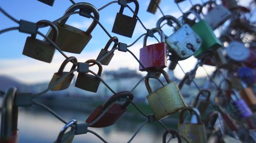 Close-up of padlocks on railing against bridge