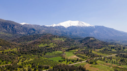 Scenic view of field and mountains against clear sky