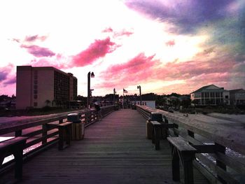 Empty road against cloudy sky at sunset