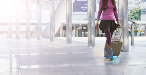 Low section of woman walking in corridor of building