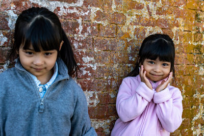 Portrait of smiling girl against wall