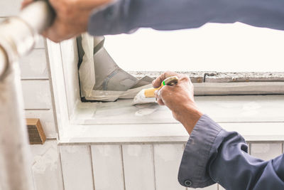 Close-up of man painting wood