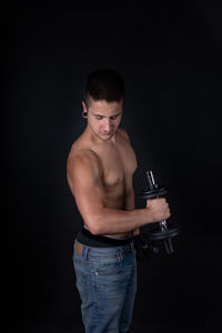 Young man looking away against black background