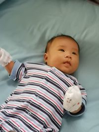 High angle view of baby lying on bed