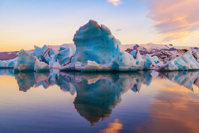 Scenic view of frozen lake against sky during sunset