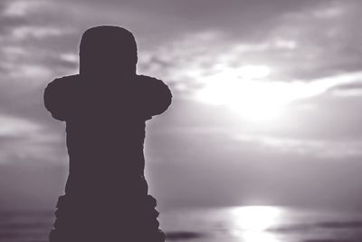 Silhouette man standing at beach against sky