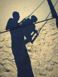 Shadow of people on field during sunny day