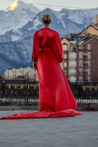 Rear view of woman standing against building
