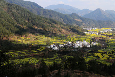 Buildings by mountains against sky