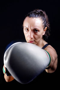 Portrait of aggressive boxer against black background