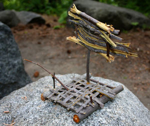 Close-up of wooden toy raft on rock