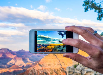 Cropped image of person photographing grand canyon national park with smart phone