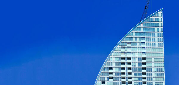 Low angle view of modern building against clear blue sky