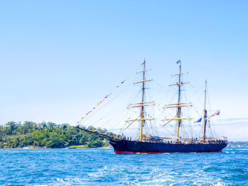 Sailboat sailing on sea against clear sky