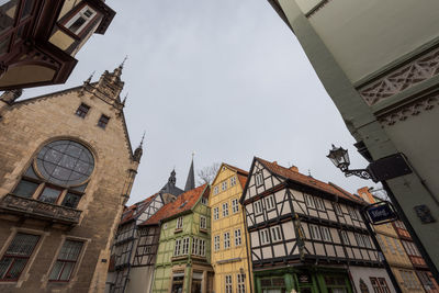 Low angle view of clock tower amidst buildings in city