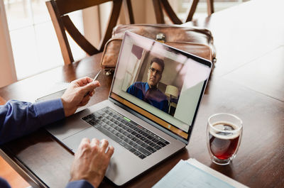 Man in virtual business meeting on computer while working from home.