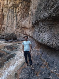 Full length portrait of man standing on rock