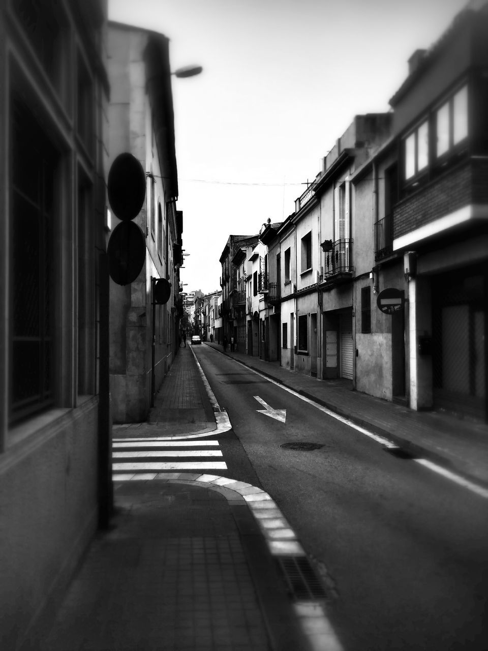 building exterior, architecture, built structure, the way forward, street, transportation, diminishing perspective, road, city, road marking, vanishing point, residential structure, sky, building, residential building, clear sky, empty, car, narrow, outdoors