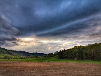Scenic view of field against cloudy sky