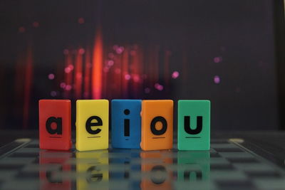 Close-up of toy blocks with vowels on table