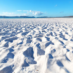 Scenic view of snow covered land against blue sky