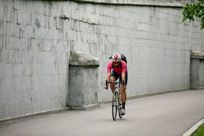 Rear view of man riding bicycle on street