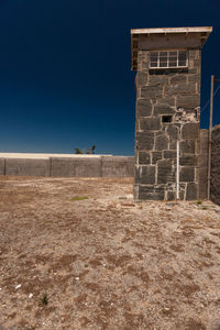 Low angle view of building on field against clear sky