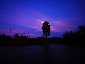 Silhouette trees on landscape against romantic sky at sunset