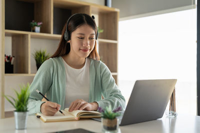 Young woman using laptop at table