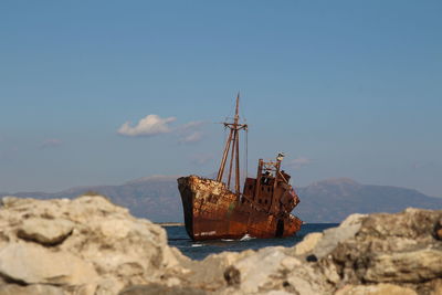 Abandoned boat on shore against sky