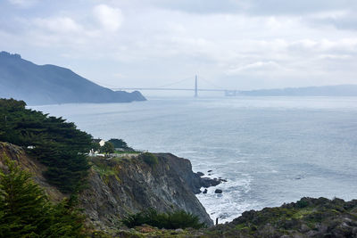 Scenic view of suspension bridge over sea against sky