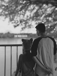 Rear view of father and daughter against river