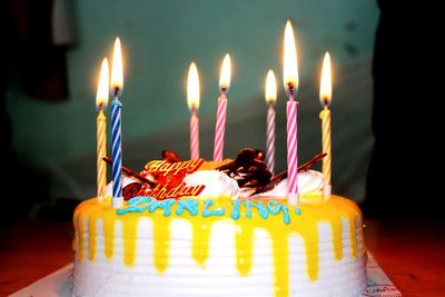 Illuminated burning candles on cake at home