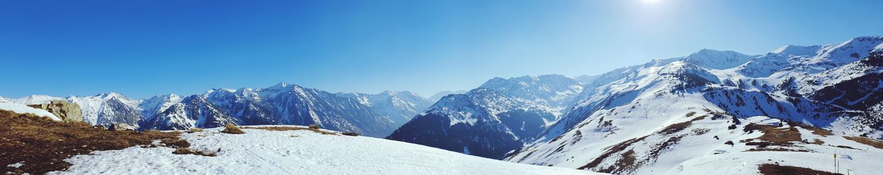 Scenic view of snowcapped mountains against clear blue sky