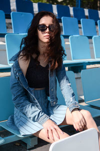 Portrait of young woman using mobile phone while sitting at cafe