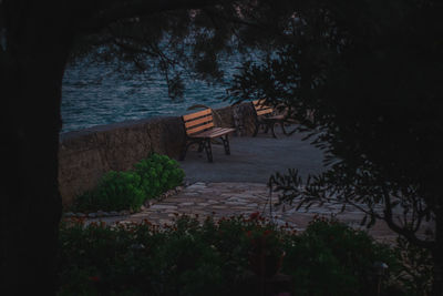 Empty bench on shore by sea