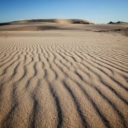 Sand dune in desert against clear sky