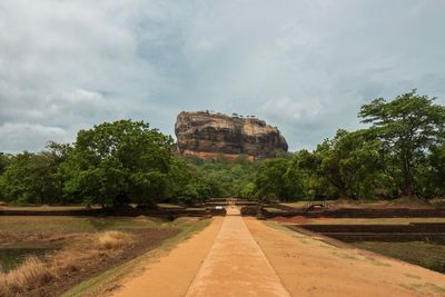 Rock formation amidst trees against sky