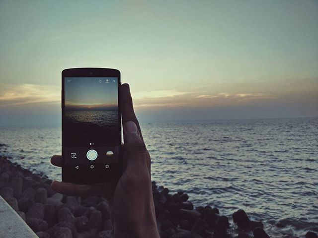 sea, sunset, horizon over water, water, sky, personal perspective, part of, scenics, beach, cropped, leisure activity, person, lifestyles, holding, transportation, photography themes, beauty in nature