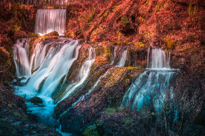 View of autumn waterfall with colorful leaves