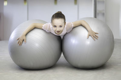 Portrait of cute girl playing with dumbbells on table