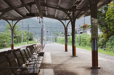 Empty chairs and table against trees