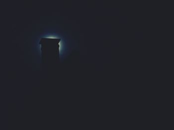 Low angle view of illuminated light against black wall