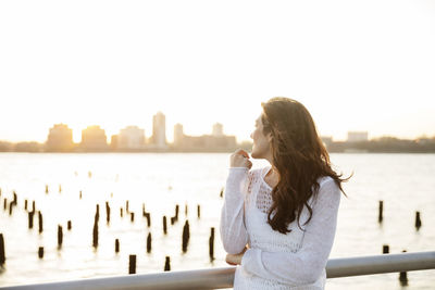 Young woman looking at city view during sunset